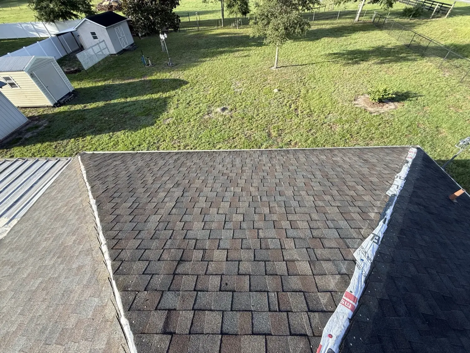 New shingles going on beside an existing metal roof section in Sumter County, FL