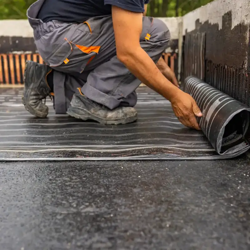 Membrane being rolled out on a flat roof by Tippy Top Roof Repair
